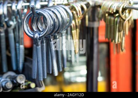 Hook screws are hanging on the counter. It was taken in front of the store. Stock Photo