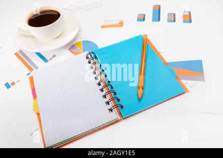Open notepad with a pen, cup of coffee and documents Stock Photo