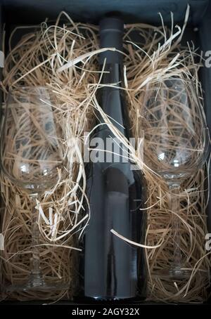 A bottle of red wine and two glasses packed as a gift Stock Photo