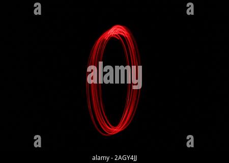 Light painting photograph of a number, drawn by fairy lights in red vibrant neon color against a black background.  Long exposure photography. Stock Photo