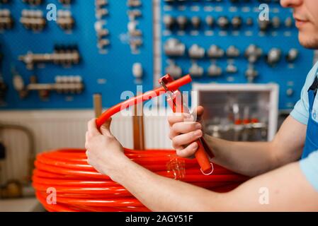 Plumber cuts plastic pipe, plumbering store Stock Photo