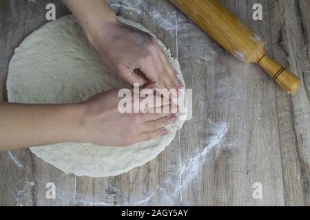 Cooling and home concept - close up of female hands holding bread Stock Photo