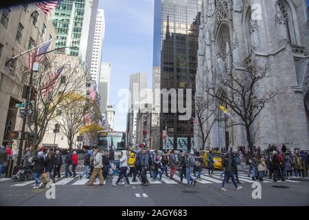 Looking north up 5th Avenue past St.  Patrick's Cathedral with crowds of tourists and shoppers in the crosswalk on Black Friday kicking off the holida Stock Photo