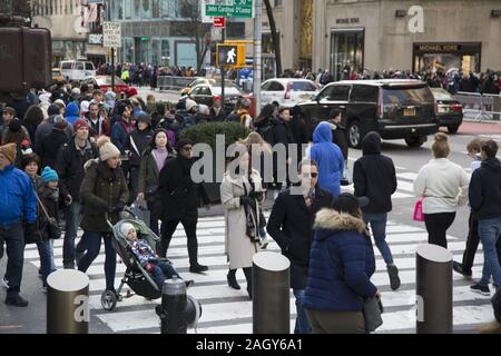 Crowds of tourists and New Yorkers kick off the holiday season on 'Black Friday' on 5th Avenue at 50th Street by Rockefeller Center in midtown Manhatt Stock Photo