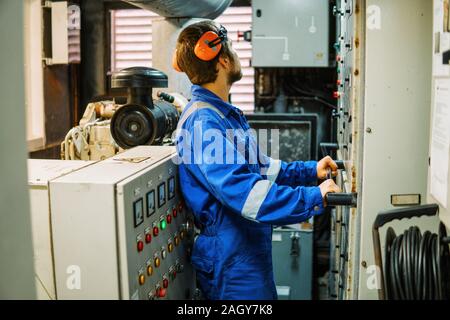 Marine engineer inspecting ship's engine or generators Stock Photo