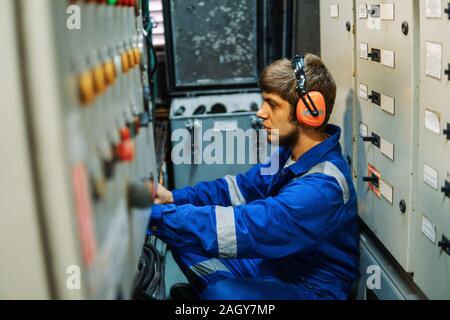 Marine engineer inspecting ship's engine or generators Stock Photo