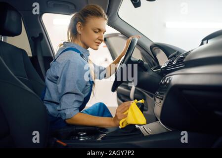 Female washer cleans automobile door trim Stock Photo