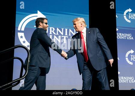 U.S President Donald Trump shakes hands with Texas Congressman Dan Crenshaw, at the Turning Point USA 5th annual Student Action Summit at the Palm Beach County Convention Center December 21, 2019 in West Palm Beach, Florida. Trump rallied the youth conservative group with wild claims on wind turbines and attacks on his opponents. Stock Photo