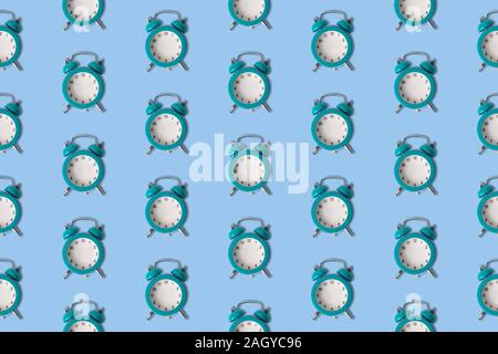 Small blue alarm clocks without hands pattern minimal creative no time concept. Stock Photo