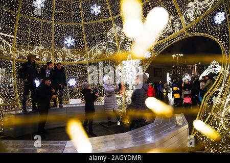 Moscow, Russia. 22nd Dec, 2019. People take pictures in an illuminated installation during the Journey to Christmas festival in central Moscow, Russia, on Dec. 22, 2019. From Dec. 13, 2019 to Jan. 12, 2020, illuminated installations decorate the holiday season among streets and squares in Moscow. Credit: Maxim Chernavsky/Xinhua/Alamy Live News Stock Photo