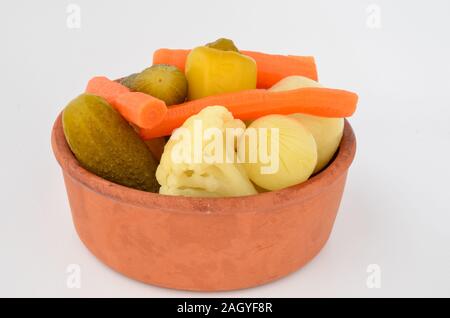 Mixed, pickled vegetables in rustic, clay bowl Stock Photo