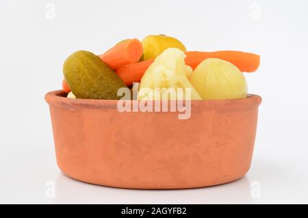Mixed, pickled vegetables in rustic, clay bowl Stock Photo