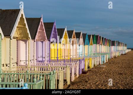 Colourful wooden beach huts at West Mersea, Mersea Island, Essex, UK during a break in the winter weather. December afternoon Stock Photo