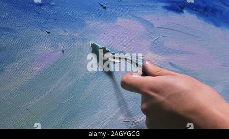 Artist copyist paint seascape with ship in ocean. Craftsman decorator draw as boat sail on blue sea with acrylic oil color. Draw finger brush palette. Stock Photo