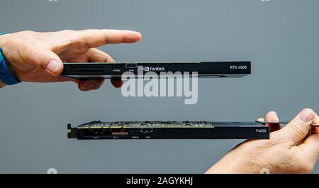 Paris, France - Mar 28, 2019: Man hands comparing latest Nvidia Quadro professional GPU video card RTX 4000 With P4000 with multiple cuda processors Stock Photo