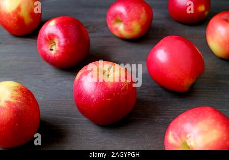Fresh red apples scattered on dark colored wooden table Stock Photo