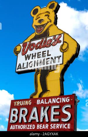 A rare, yellow, neon Happy Bear sign, the logo of a defunct wheel alignment manufacturer. It's displayed outside an old authorized Bear Service shop. Stock Photo