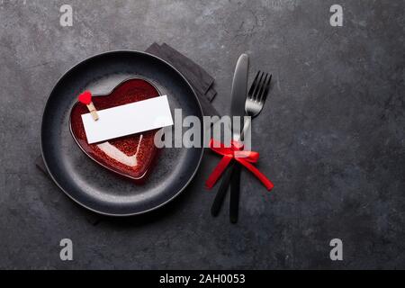 Valentines day or romantic dinner table setting over stone background. Top view flat lay with copy space for your greetings