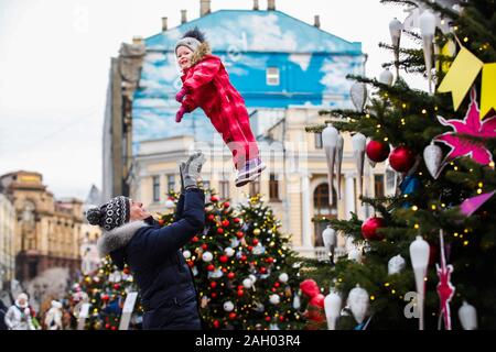 Beijing, Russia. 22nd Dec, 2019. A man throws his child in the air during the Journey to Christmas festival in central Moscow, Russia, on Dec. 22, 2019. From Dec. 13, 2019 to Jan. 12, 2020, illuminated installations decorate the holiday season among streets and squares in Moscow. Credit: Maxim Chernavsky/Xinhua/Alamy Live News Stock Photo