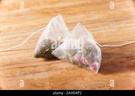 Two packs of cranberry green tea tea bags on wooden board Stock Photo
