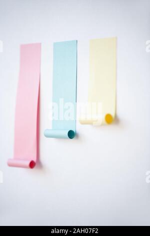 Chart made up of pink and smaller blue and yellow notepapers stuck on whiteboard in isolation Stock Photo