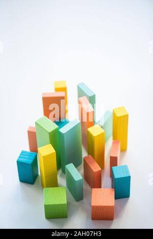 Blue, orange, yellow and green flat wooden bricks and cubes making up chart in isolation with copyspace above Stock Photo