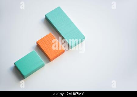 Orange and blue flat wooden bricks making up chart against white background with copyspace surrounding them Stock Photo