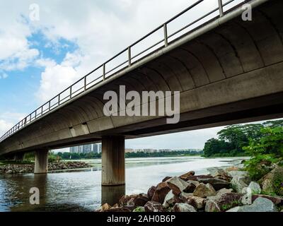 Scenic view of railway / subway / train bridge across a lake / reservoir in Singapore with residential flats in the background Stock Photo