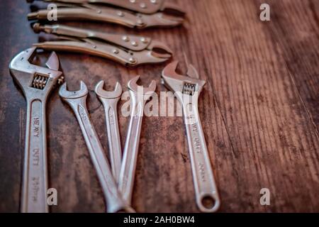 Selective focus on DIY wrench tools on a plain wooden background Stock Photo