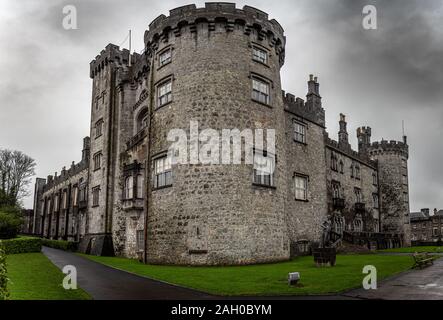 KILKENNY, IRELAND, DECEMBER 23, 2018: Kilkenny Castle seen from the corner of its entrance on a dramatic cloudy day. Stock Photo