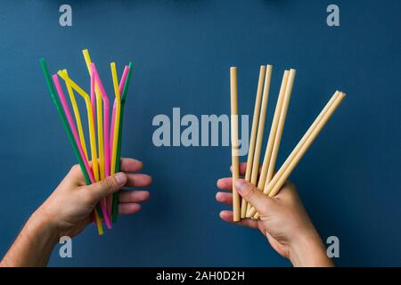 bamboo and plastic straws in hands Stock Photo