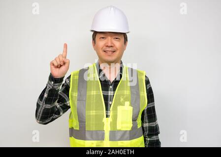 Asian middle-aged man in a Light green work vest and white safety hat. Stock Photo