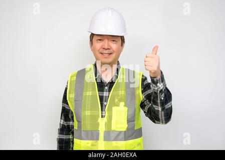 Asian middle-aged man in a Light green work vest and white safety hat. Stock Photo