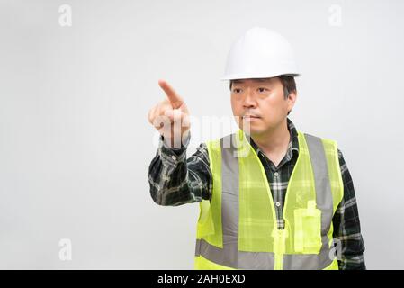 Asian middle-aged man in a Light green work vest and white safety hat. Stock Photo