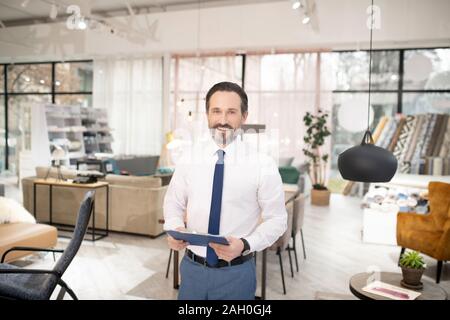 Furniture designer in tie and white shirt feeling positive Stock Photo
