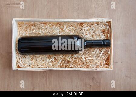 Bottle of wine in wooden box with straw Stock Photo