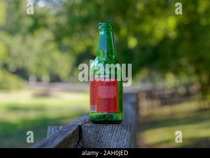 The back label of a Woodchuck Hard Cider Green Glass Bottle sitting on a wooden Fencepost in Texas. Stock Photo