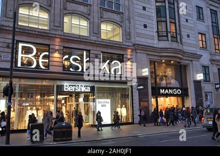LONDON, UK - APRIL 23, 2016: People shop at Bershka and Mango, Oxford Street in London. Oxford Street has approximately half a million daily visitors Stock Photo