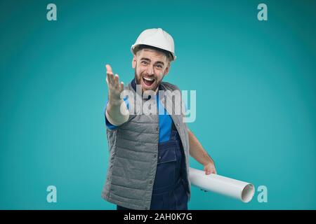Horizontal medium portrsit shot of professional construction engineer shouting something holding building plan looking at camera Stock Photo