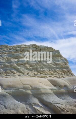 White rocky wall with blue sky background with clouds Stock Photo
