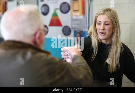 Ellie Goulding serves coffee to a guest while volunteering at a Crisis Christmas centre in London, as the charity opens its doors to homeless people for the festive period. Stock Photo