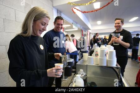 Ellie Goulding serves coffee to a guest while volunteering at a Crisis Christmas centre in London, as the charity opens its doors to homeless people for the festive period. Stock Photo