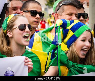 FORTALEZA, BRAZIL - 4 JULY 2014: A candid view of a pair of young female Brazilian soccer fans in their team colours and an excited mood before a matc Stock Photo