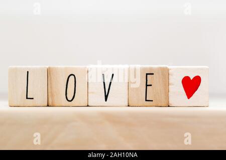 Word Love on wooden cubes with red heart, close-up near white background Stock Photo