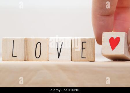 Word Love on wooden cubes with red heart, close-up near white background Stock Photo