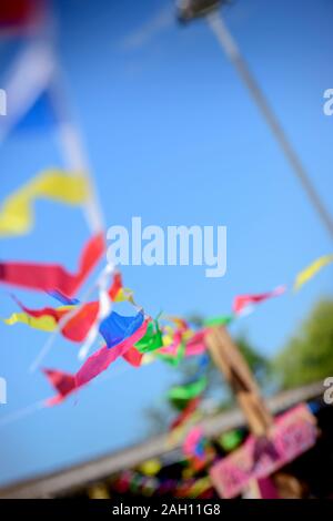 Bunting flutters in the wind against a bright blue sky. Stock Photo