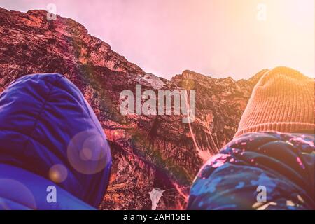 Hikers in the mountains. Two hikers enjoying sunrise from top of a mountain Stock Photo