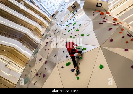 A young woman tries out the 55-meter-tall world's tallest indoor roket climbing wall at the New World City Plaza in Shanghai, China on December 20th, Stock Photo