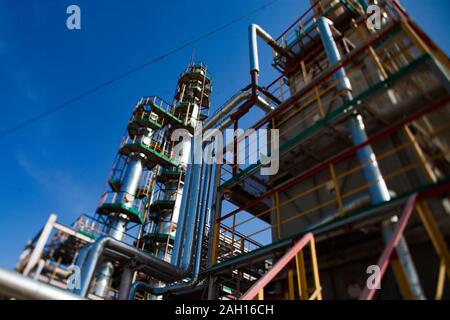 Grey oil refining columns and pipelines at the oil refinery plant on a deep blue sky. Stock Photo