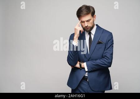 Studuo shot of thinking businessman wearing suit Stock Photo